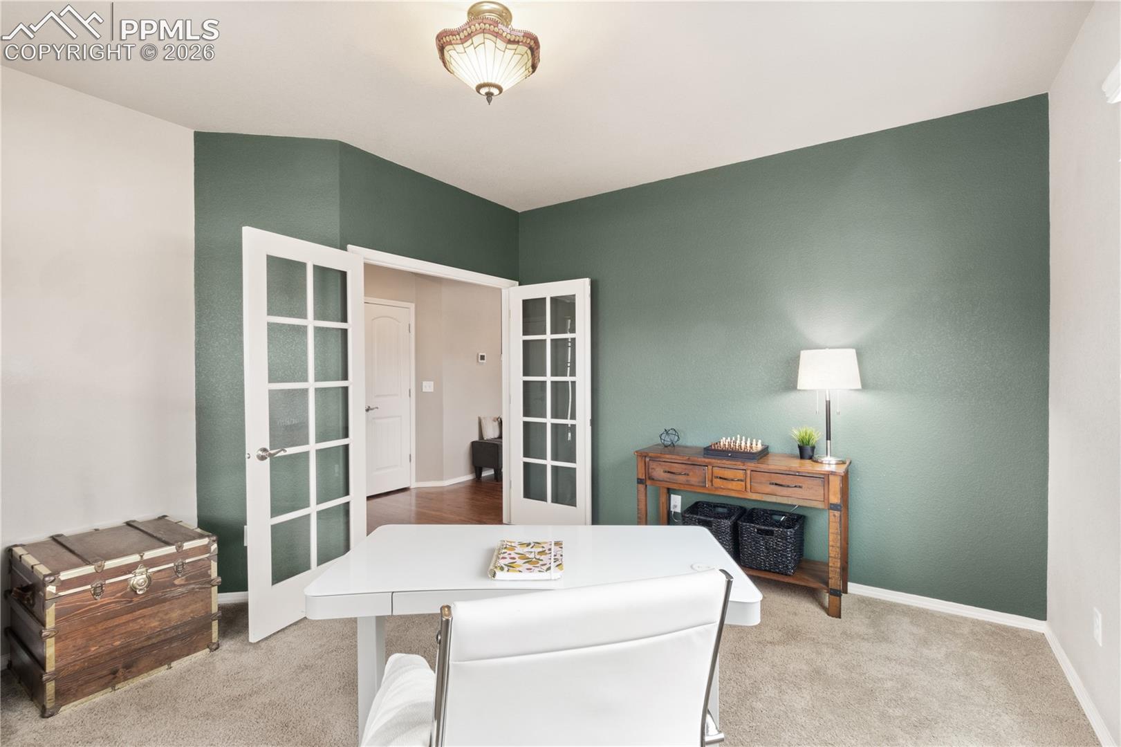 Office space with light colored carpet and french doors