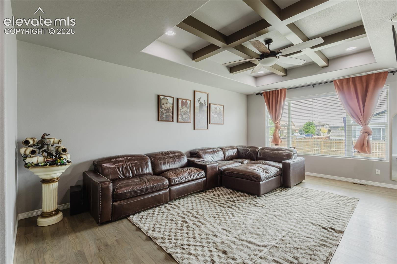Living space featuring a coffered ceiling with recessed lighting and a ceiling fan
