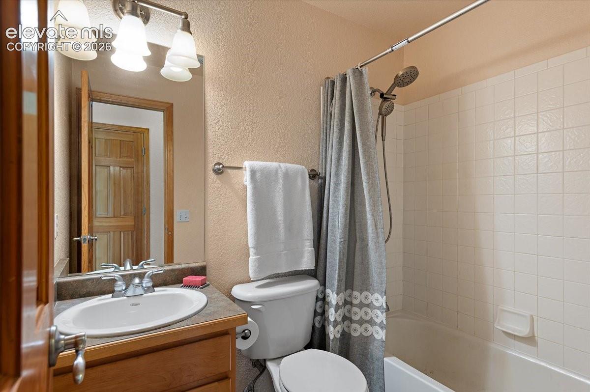Upstairs bathroom 1 featuring a vanity with a white oval sink, chrome faucet, and a stone-look countertop