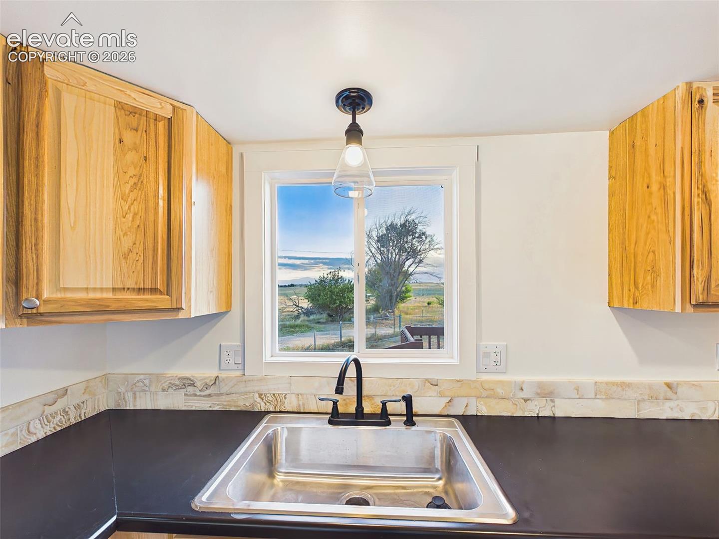 Kitchen Sink View – Window above the sink brings in natural light and provides peaceful views of the surrounding acreage / Pikes Peak while you work in the kitchen.