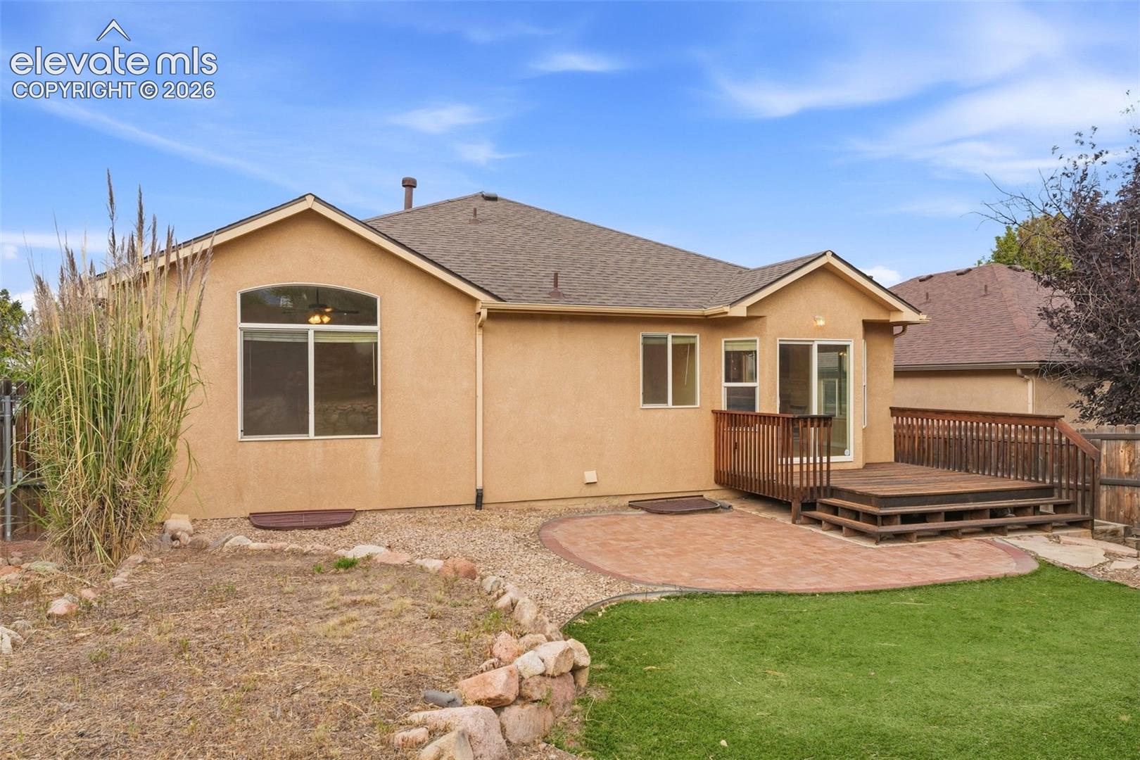 Backyard with Well-Appointed Flagstone Patio off Wood Deck