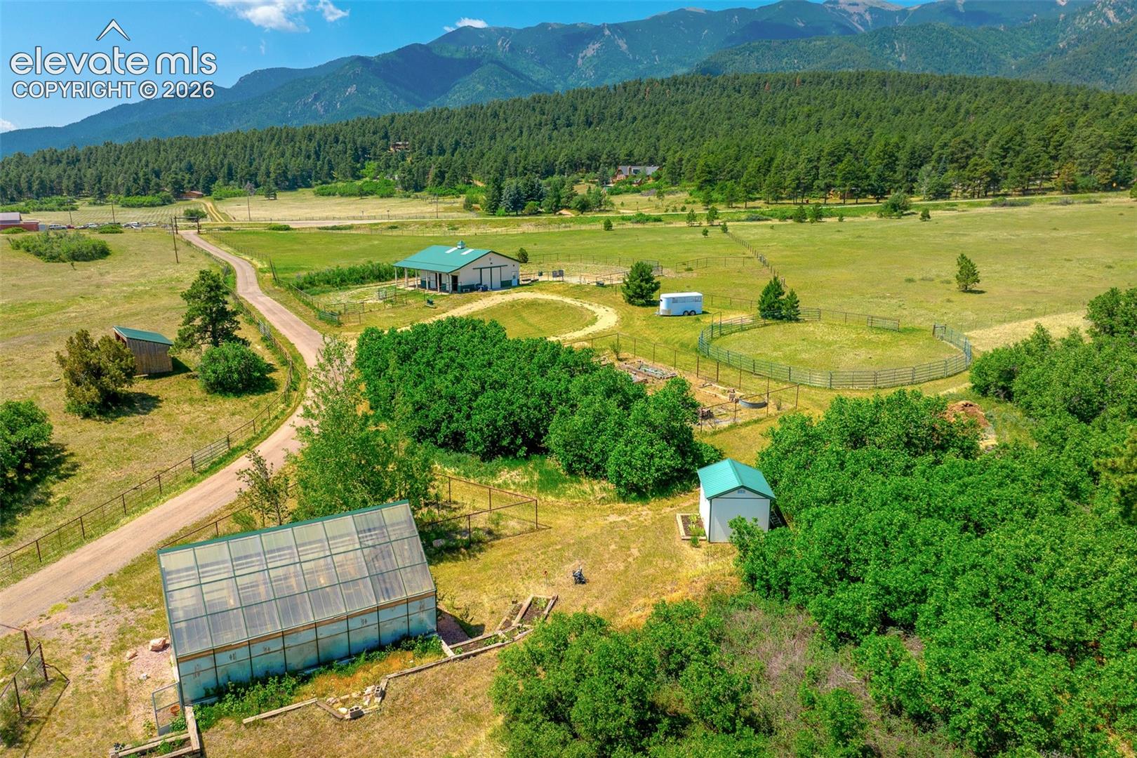 View of greenhouse and other outbuildings photographed June 2026