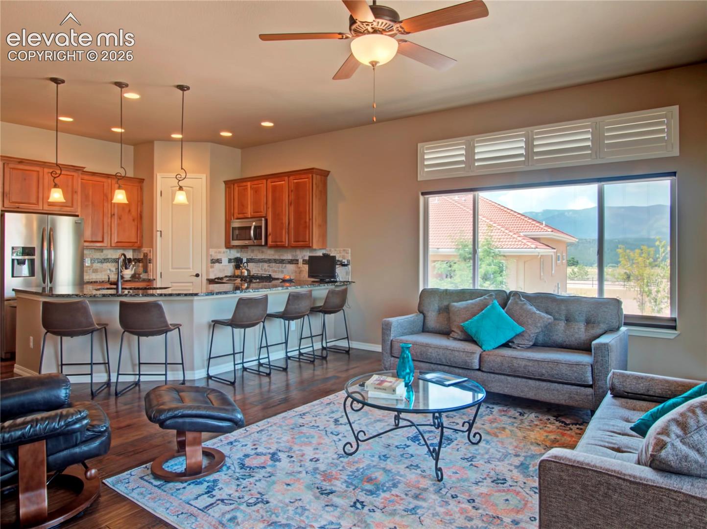 Open-concept living space featuring wood-finish flooring and a ceiling fan and walk out to covered patio.