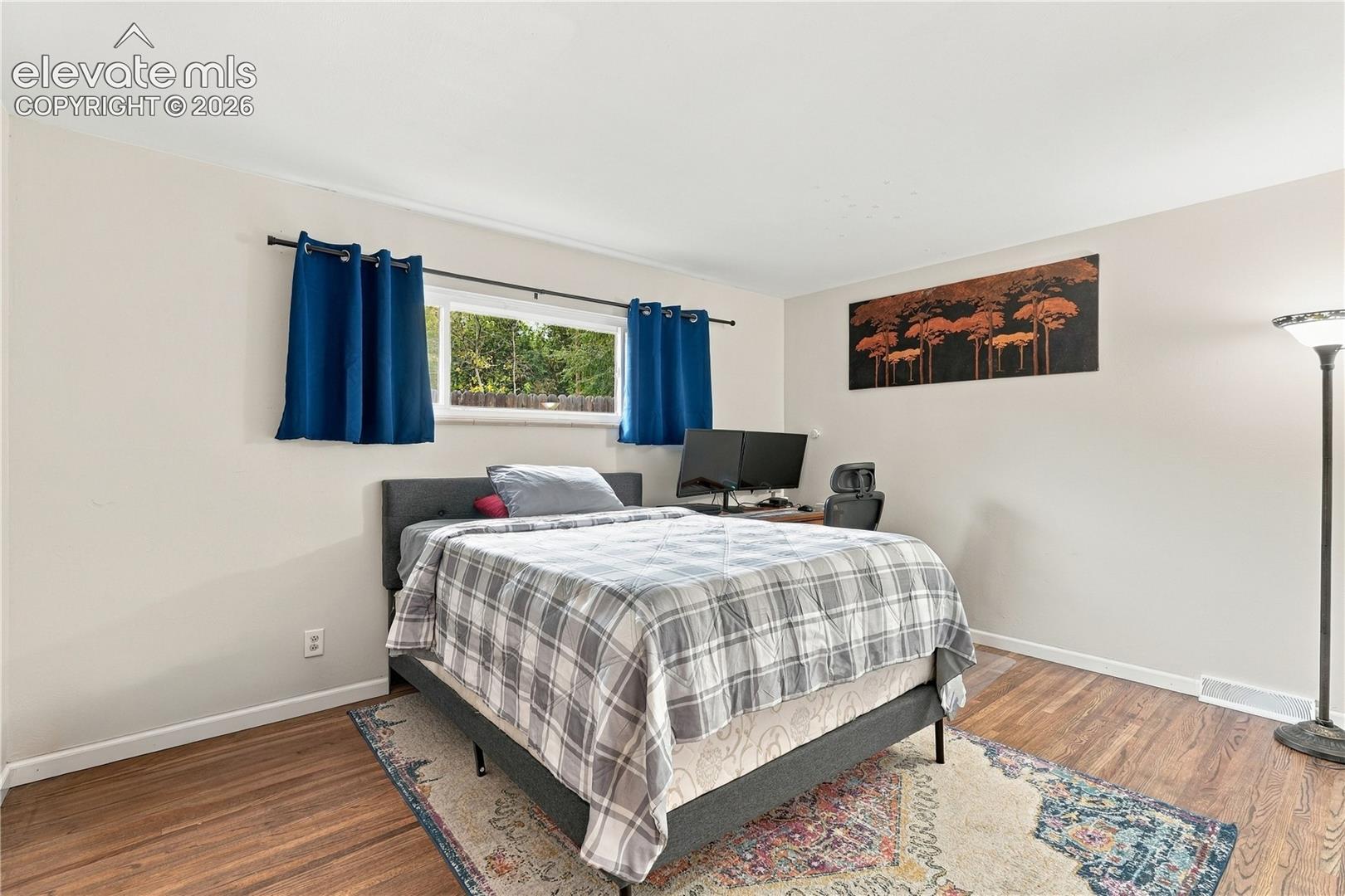 Neutral interior room featuring wood-finish flooring and a horizontal window