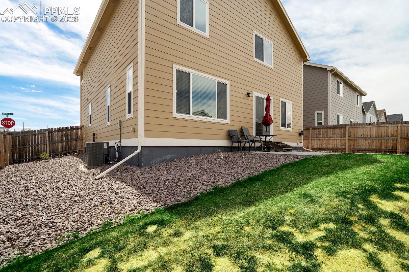 Back of property with a fenced backyard and a patio