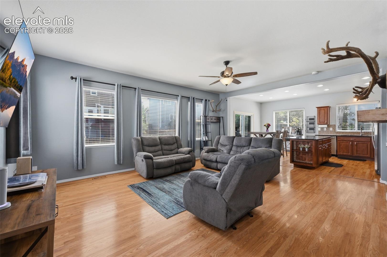 Hardwood flooring throughout, recessed lighting, and a ceiling fan