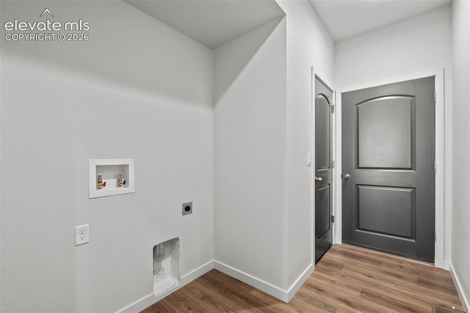 Wood-finish flooring with white trim and light gray walls