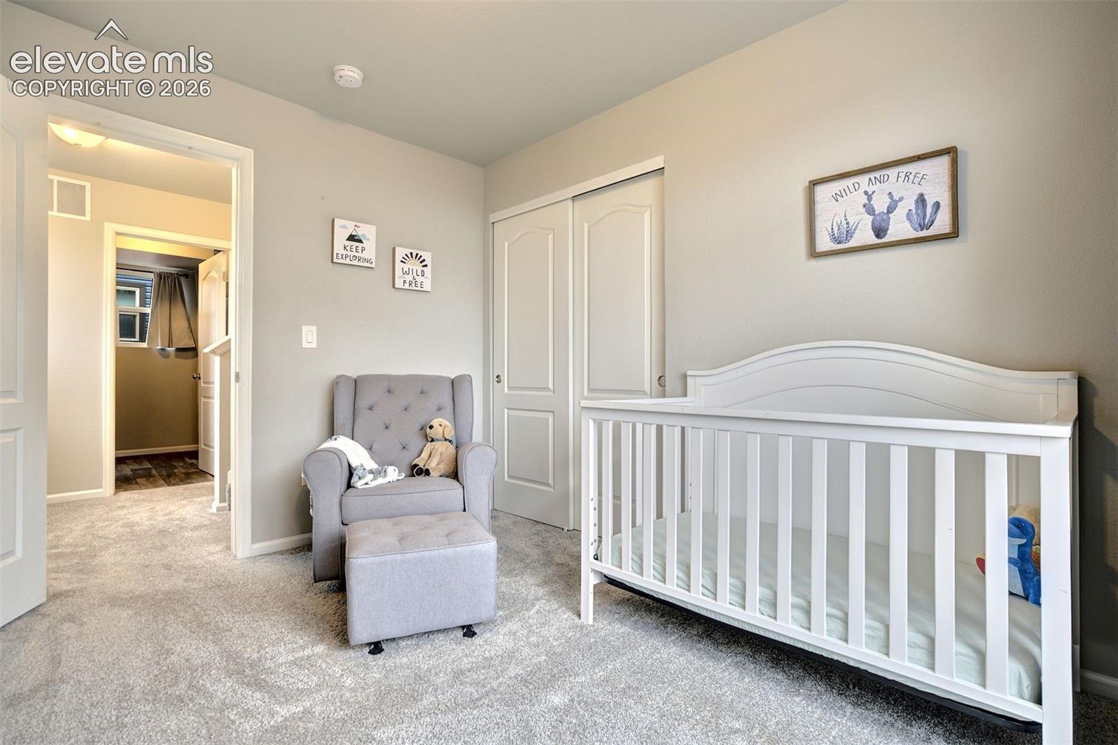 Neutral interior featuring wall-to-wall carpeting and dual-panel closet doors
