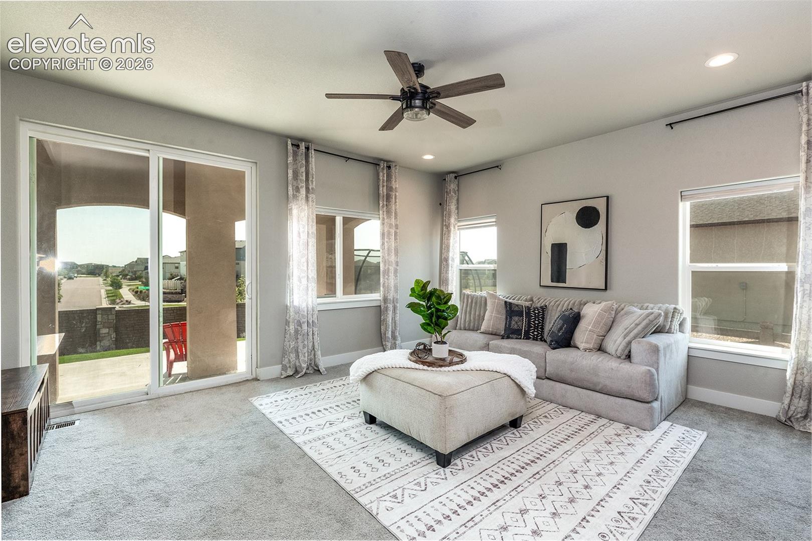 Sliding glass door to an outdoor patio, multiple windows, recessed lighting, and a ceiling fan