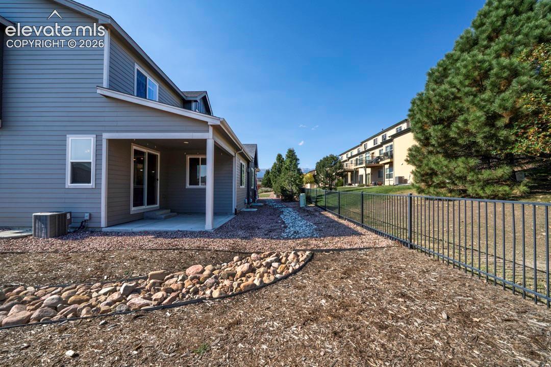 Covered patio with concrete flooring, sliding glass door entry, and two windows