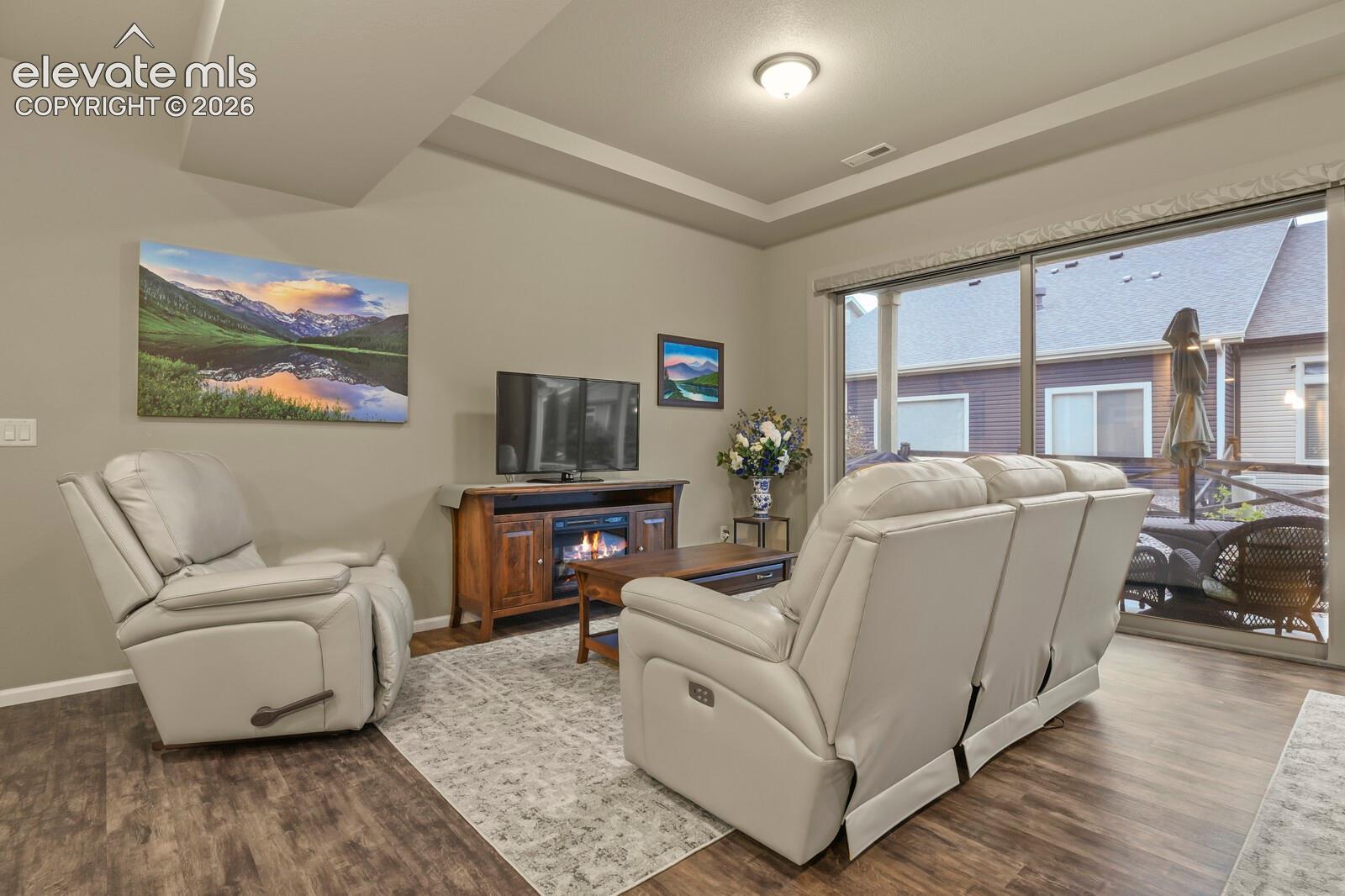 Tray ceiling, wood-finish luxury tile flooring, and Walk out sliding glass door opening to an 18'x 9' Patio