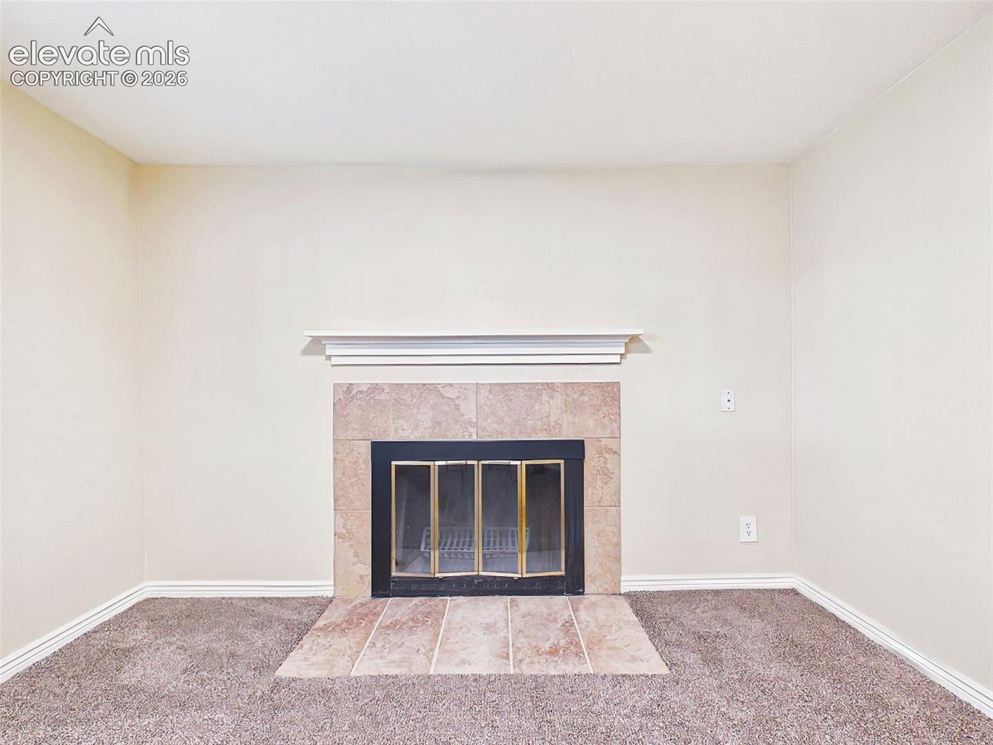 Fireplace Detail – Tile-surround fireplace with a classic mantel serves as an attractive focal point for the family room.