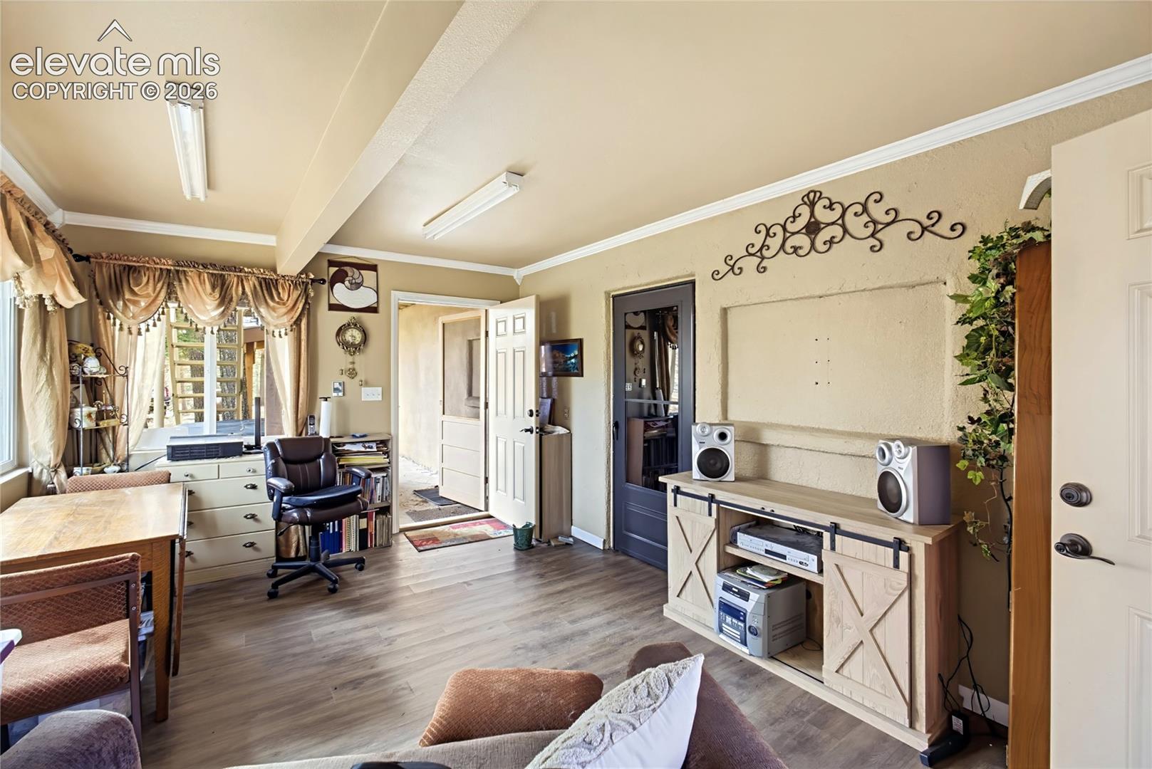 Interior space featuring wood-finish flooring, recessed wall niche, crown molding, and dual-pane windows