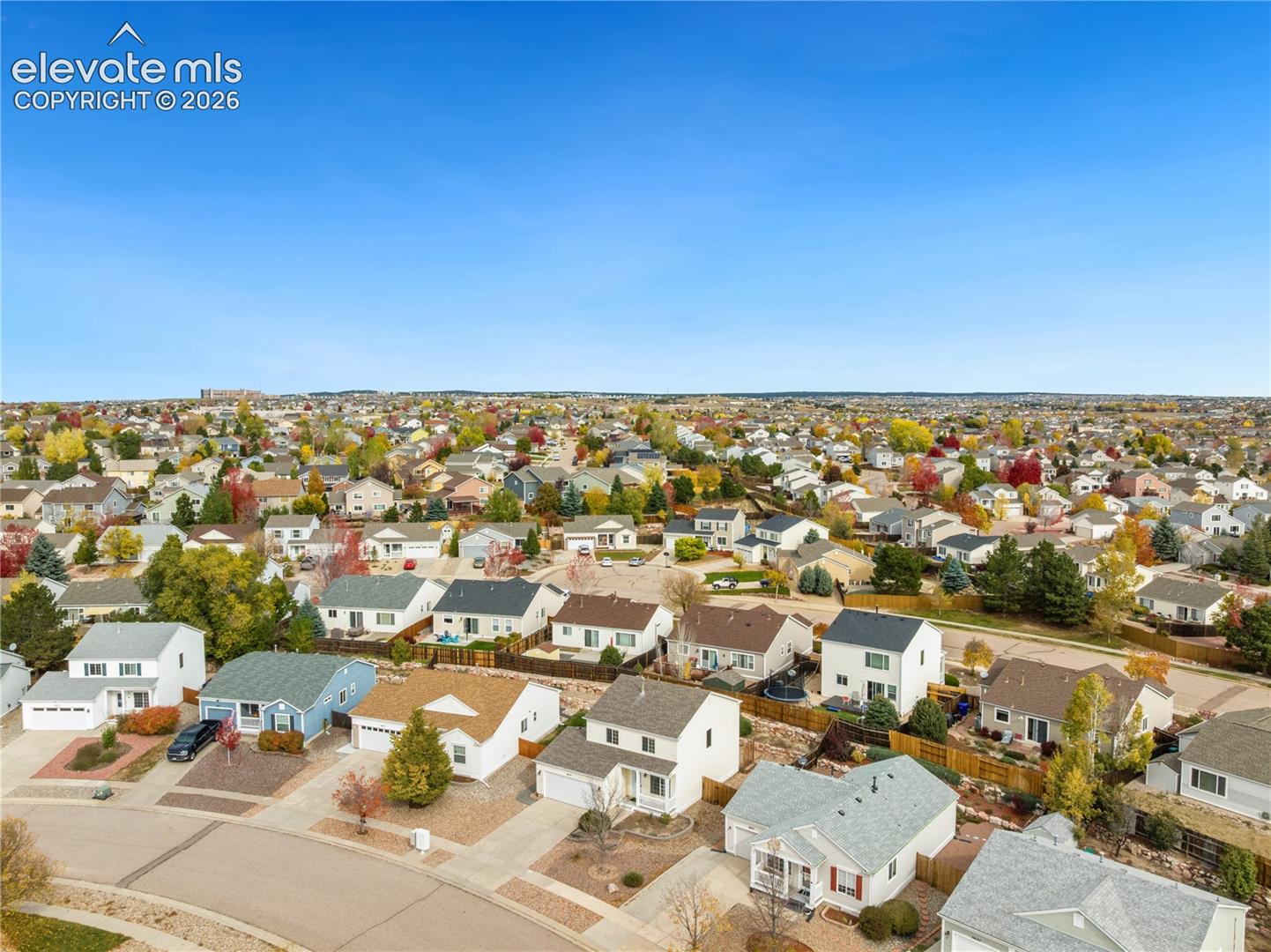 Aerial perspective of a suburban neighborhood featuring paved streets, established residential lots, and mature trees