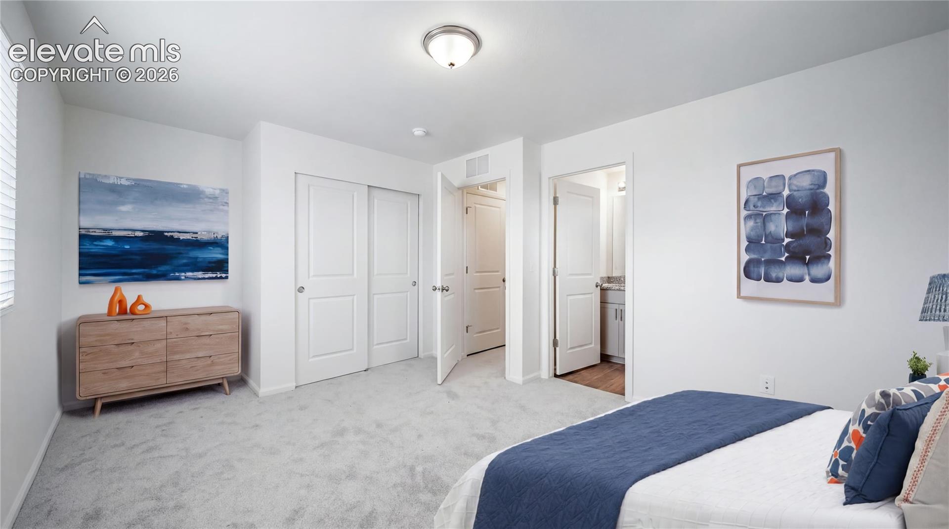 Carpeted bedroom with a window, white walls, and a sliding closet door
*photos of a model home*