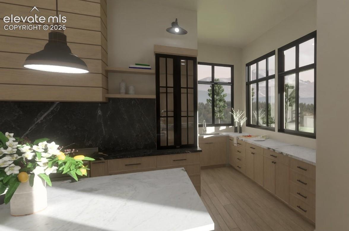 Secondary prep kitchen with wood-finish plank flooring, light-toned cabinetry, white stone-finish countertops, black stone-finish backsplash, and black-framed windows