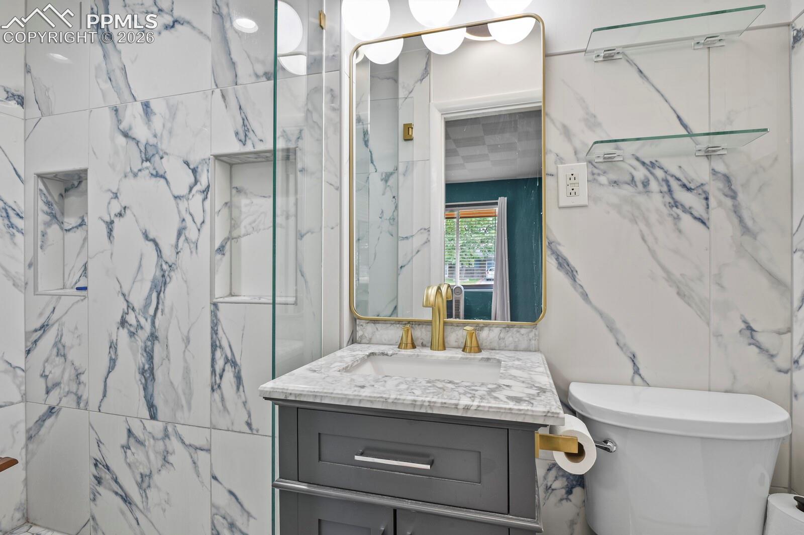 Private primary 3/4 bathroom featuring large-format porcelain tile with blue veining