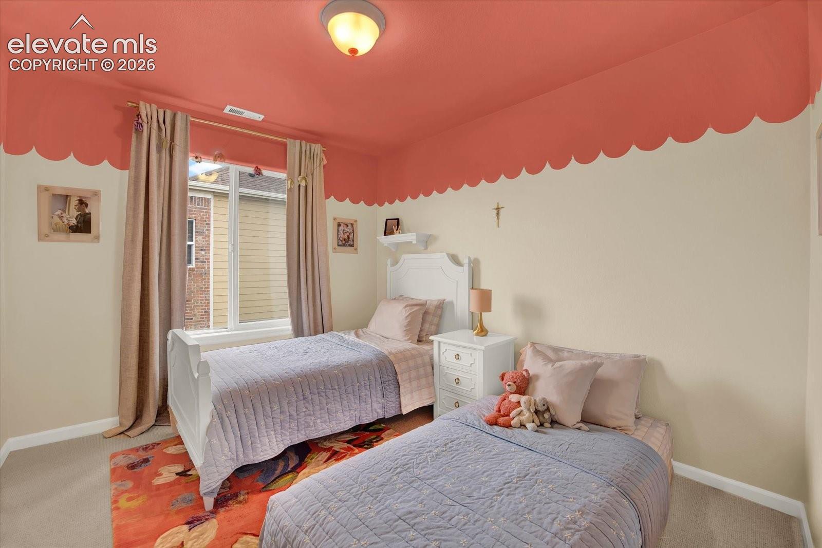 Neutral carpeting, central flush-mount ceiling light fixture, and large single-pane window with a custom scalloped paint detail