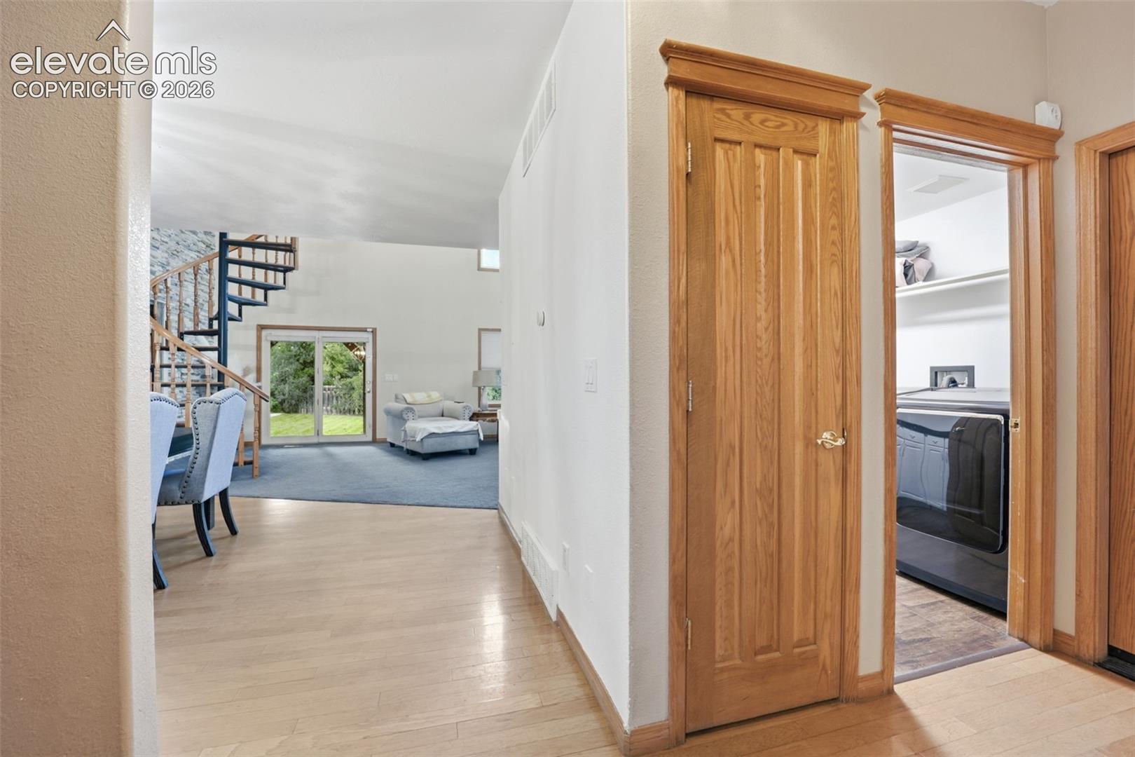 Light wood-finish flooring with a spiral staircase featuring wood treads
