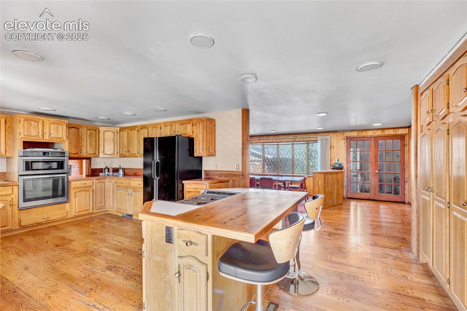 Kitchen featuring wood-finish flooring, recessed lighting, wood cabinetry, and a built-in oven and microwave