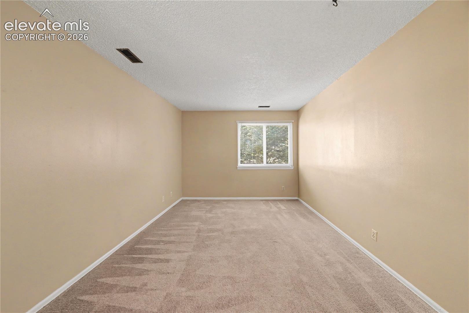 Bedroom with neutral walls and carpeted floors