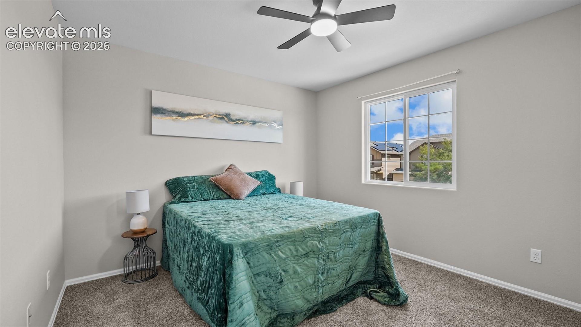 Interior room featuring light gray wall paint, a ceiling fan with integrated lighting, and a window with white framing