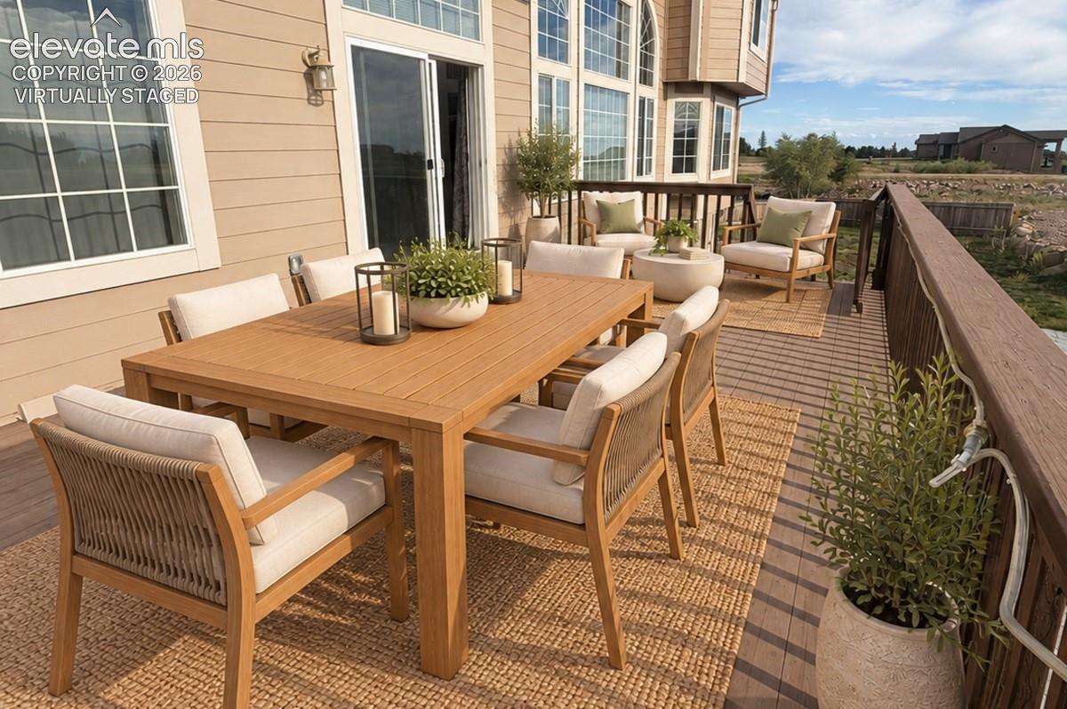 Expansive rear deck featuring composite decking and a dark wood-finish railing. Virtually staged