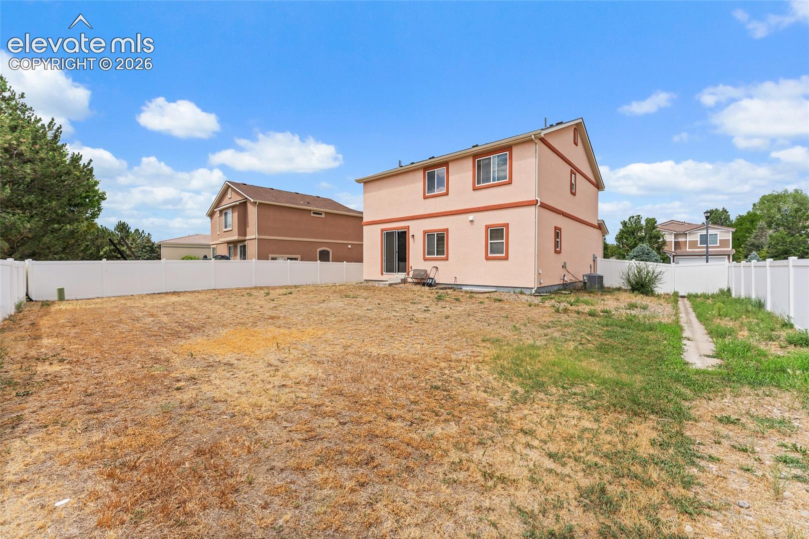Two-story residence featuring a stucco exterior, concrete patio, and a fully fenced rear yard