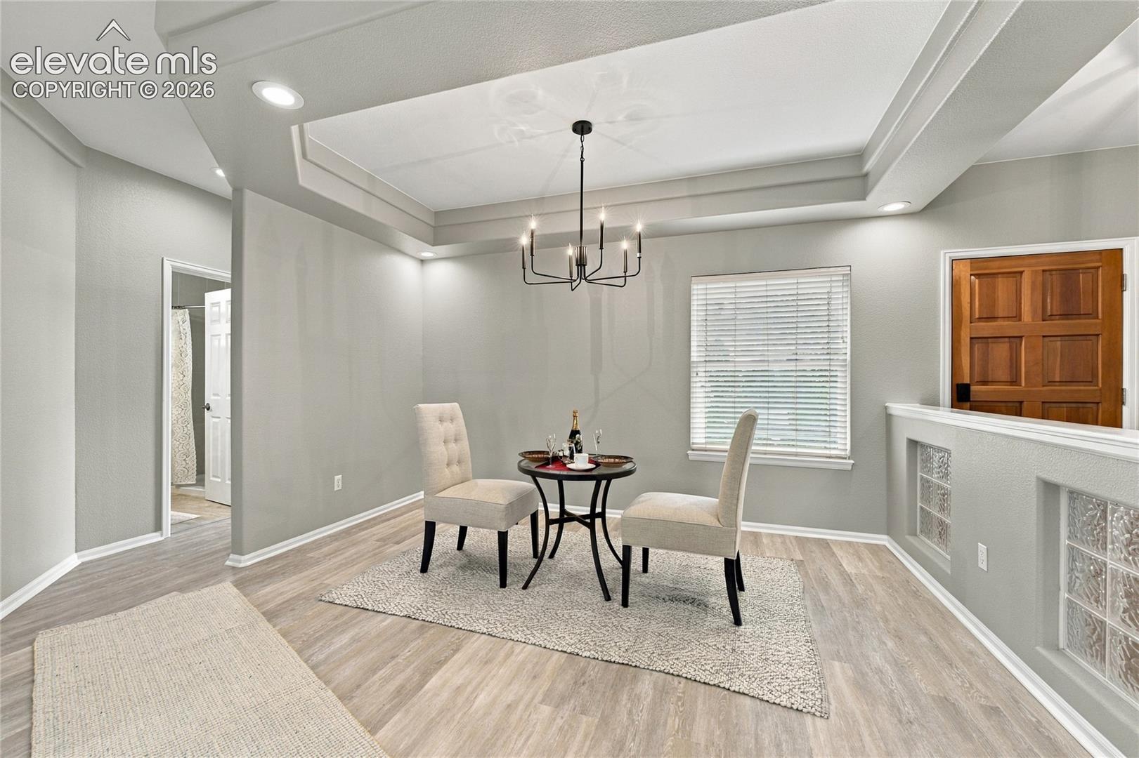 formal dining area with ceiling accents and new chandelier