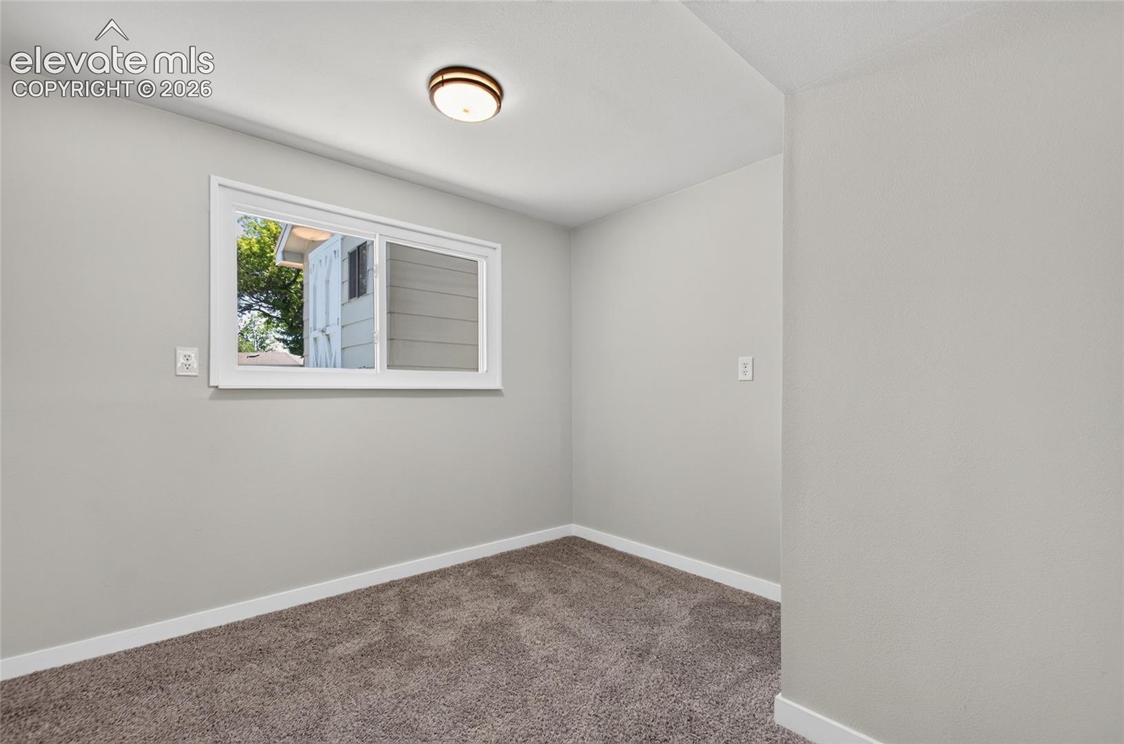 Room featuring light gray painted walls, white baseboards, and brown carpet flooring