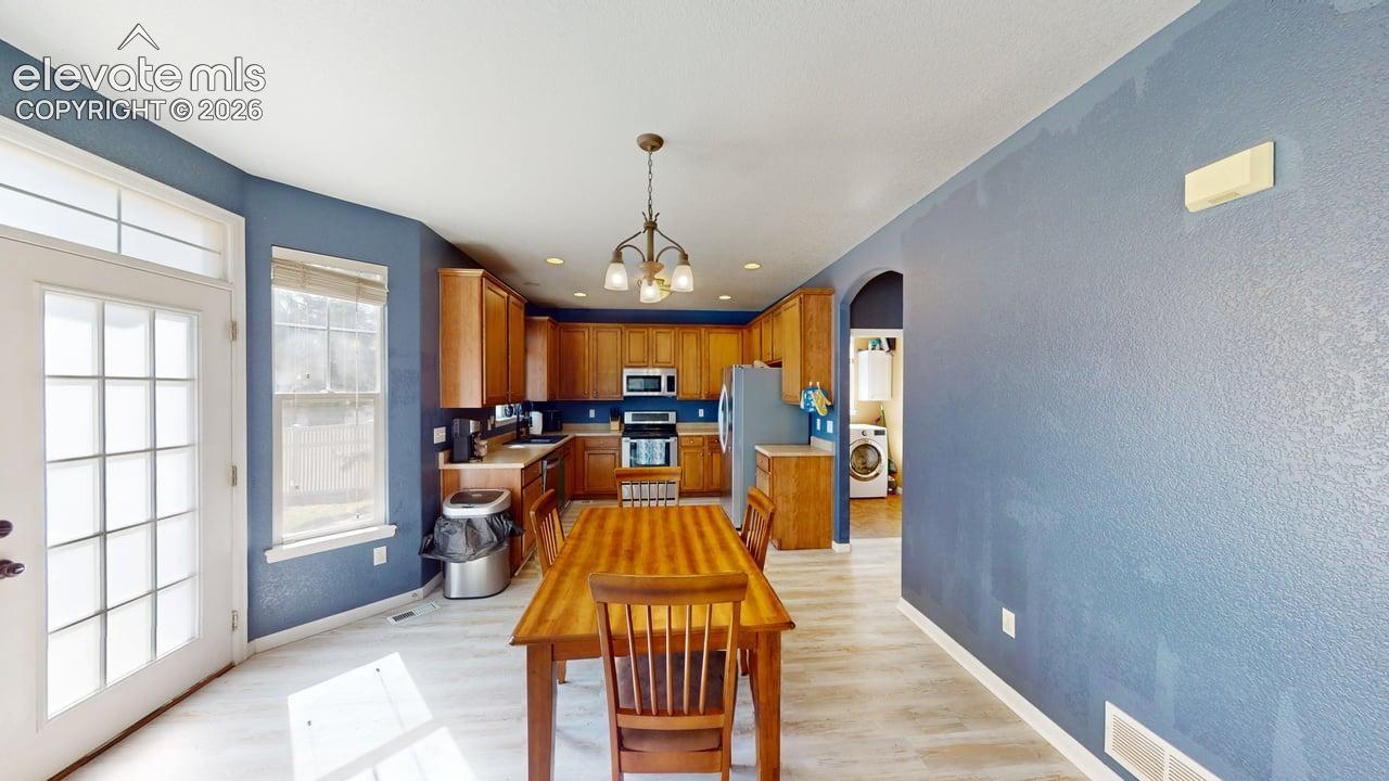 Kitchen with wood-finish flooring, recessed lighting, and a metal chandelier