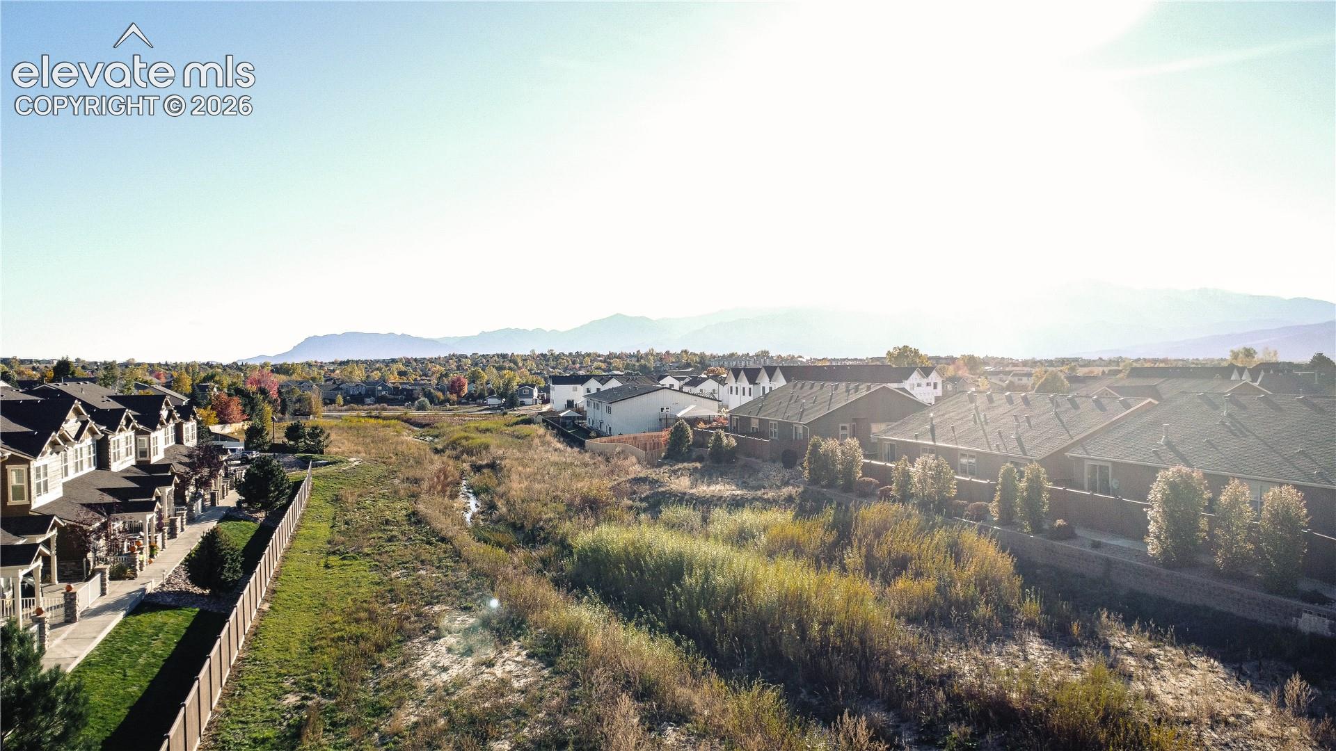 Aerial perspective featuring residential lots, mountain backdrop, and expansive natural terrain