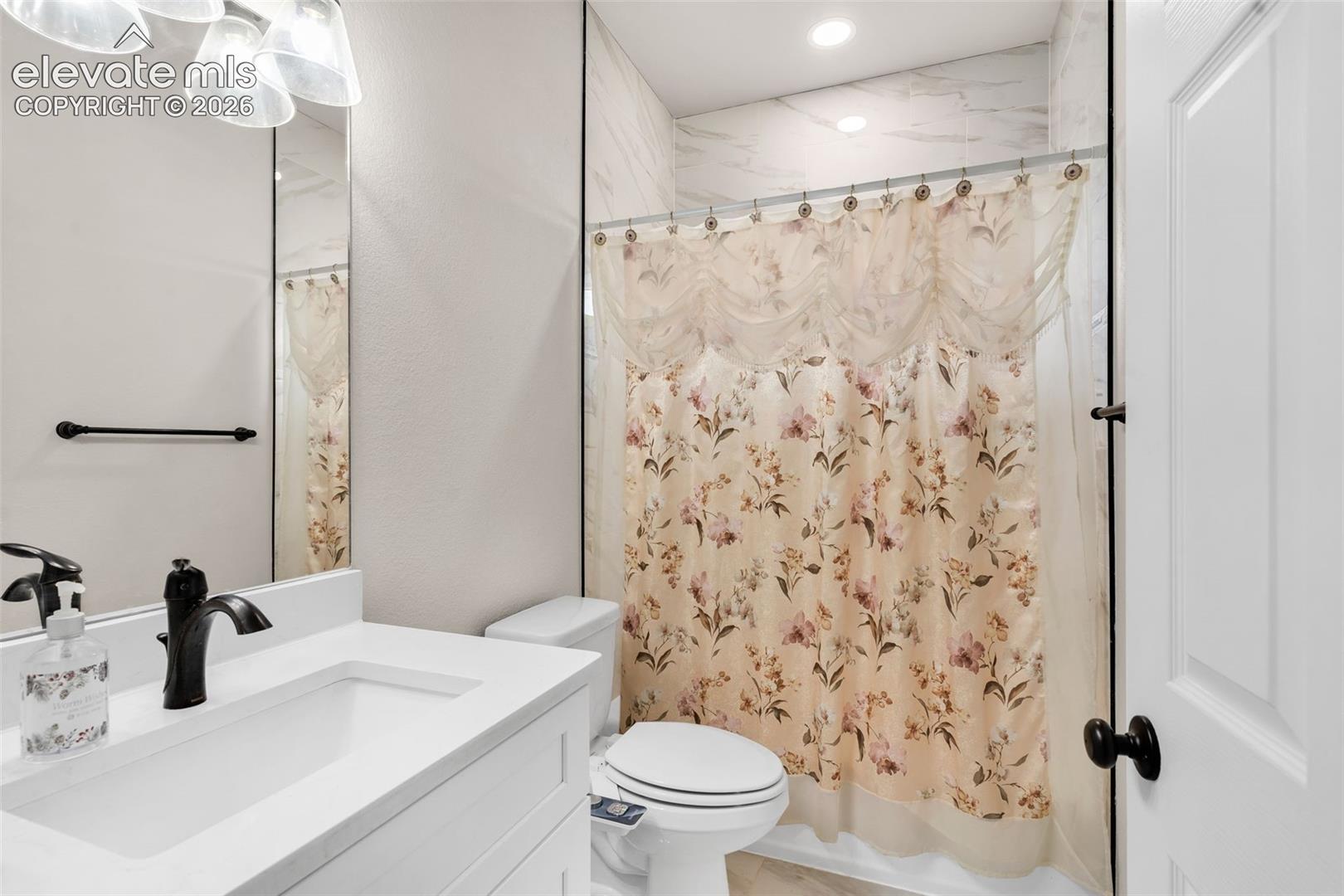 White vanity with an integrated sink, black faucet, and white countertop