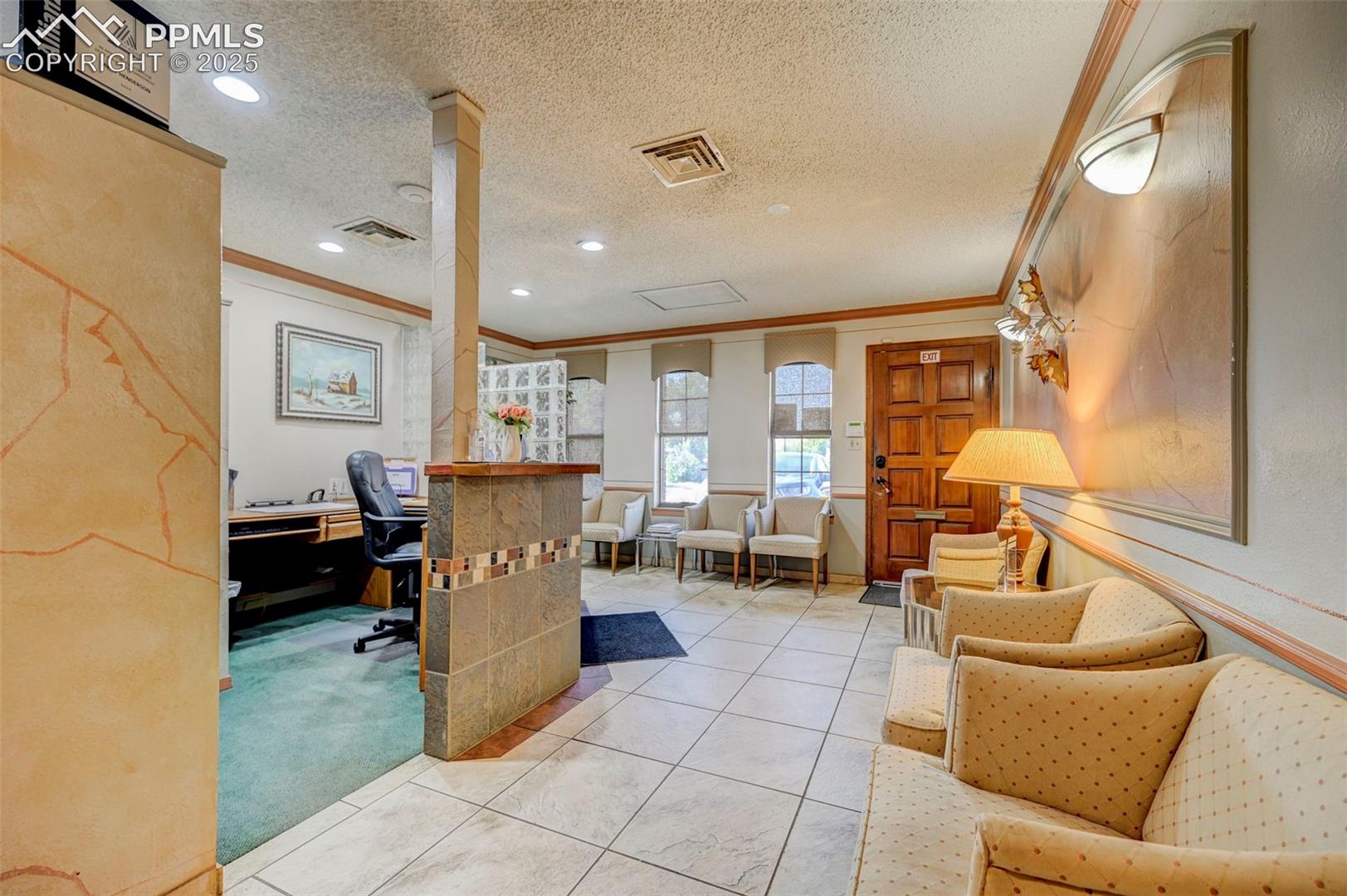 Office featuring ornamental molding, a textured ceiling, recessed lighting, light tile patterned floors, and decorative columns