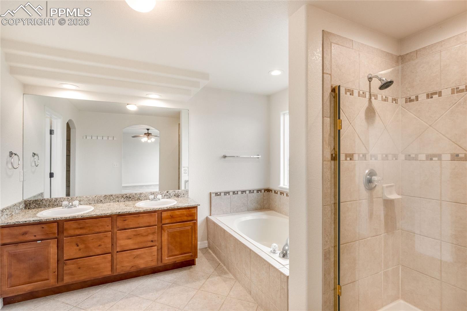 5 piece primary bathroom with soaking tub and entrance to walk-in closet.