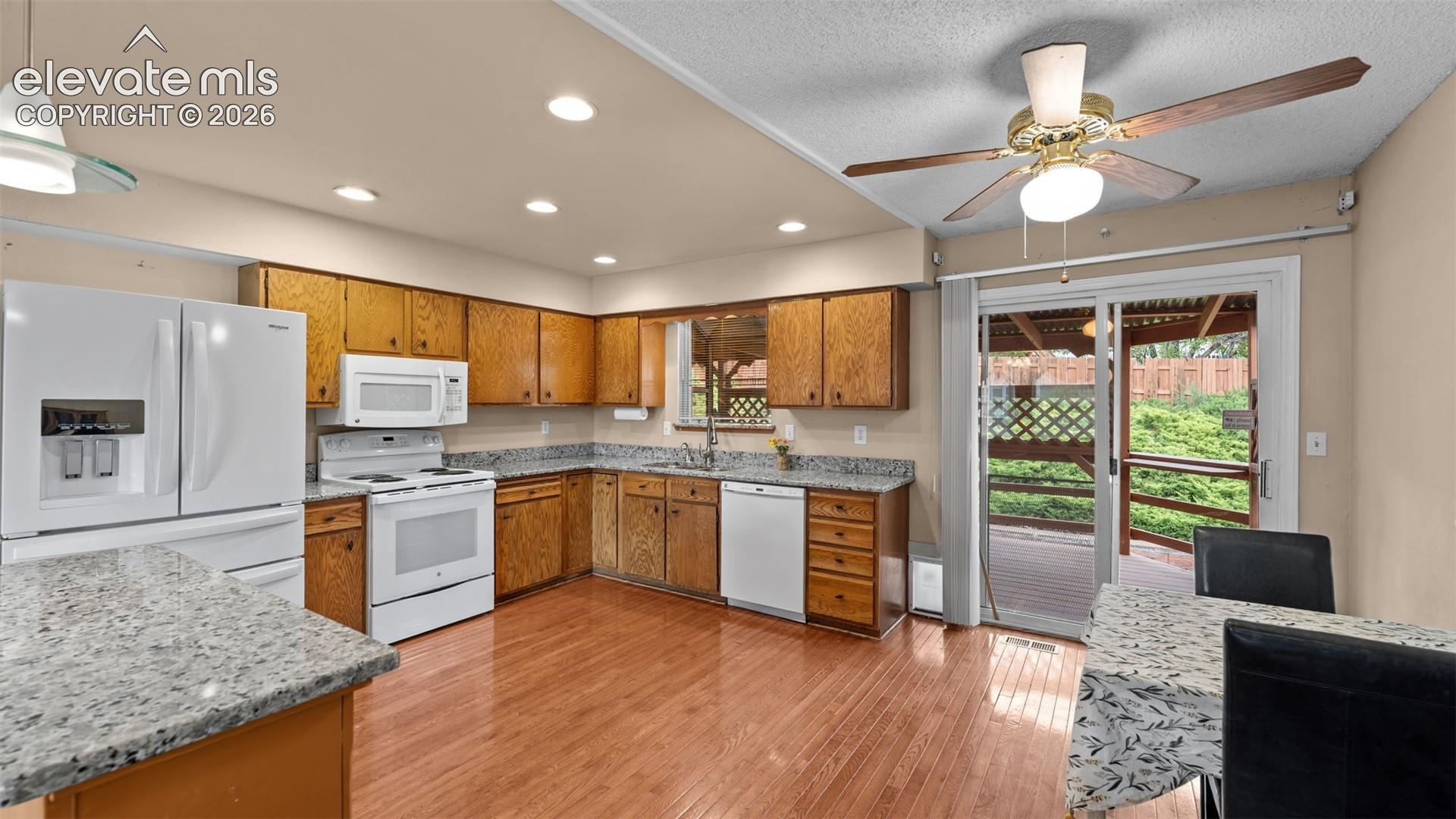 Next to the living room is the large kitchen with solid countertops and dining area with walkout to the back, covered deck.