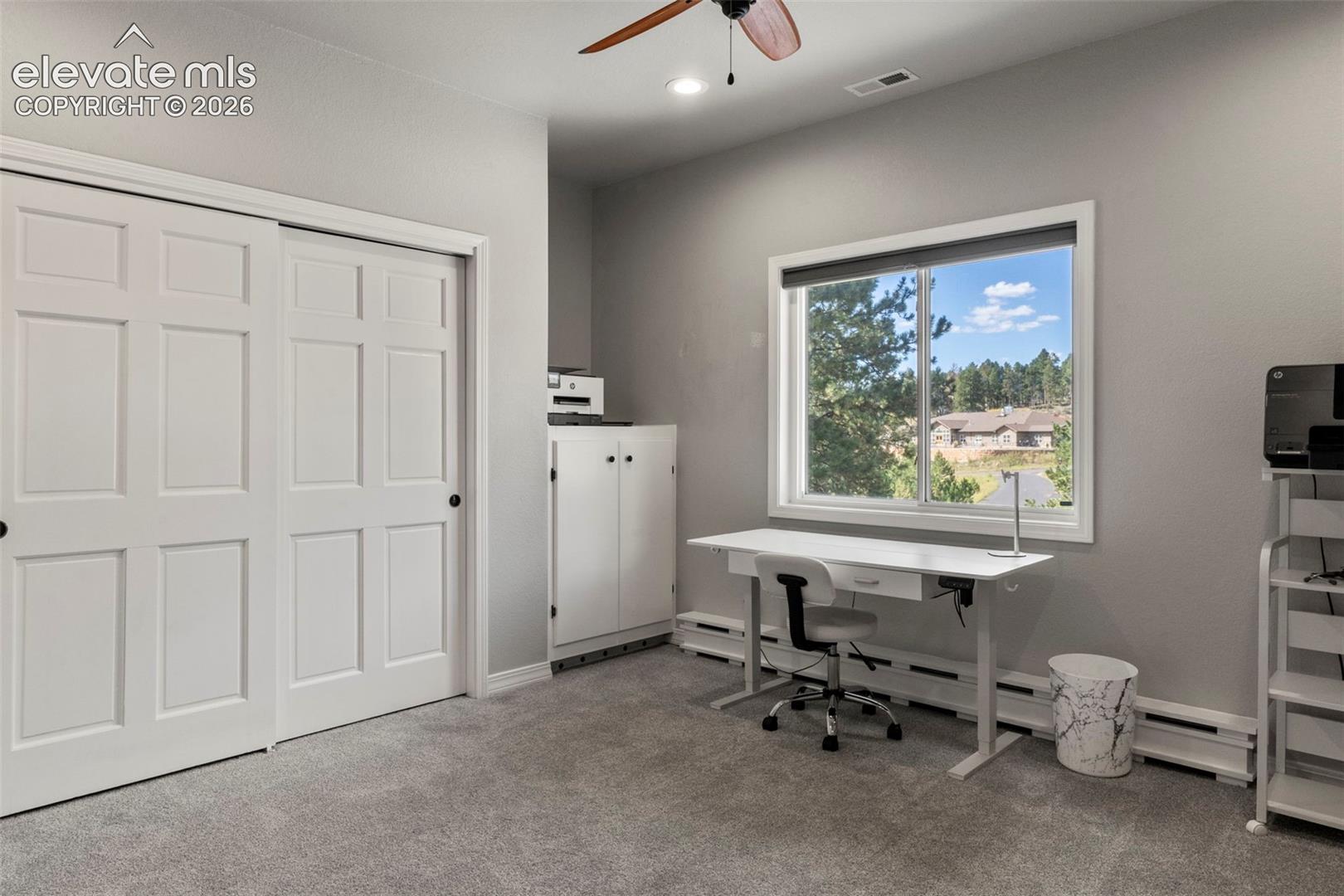 Office with light carpet, a ceiling fan, baseboard heating, and recessed lighting