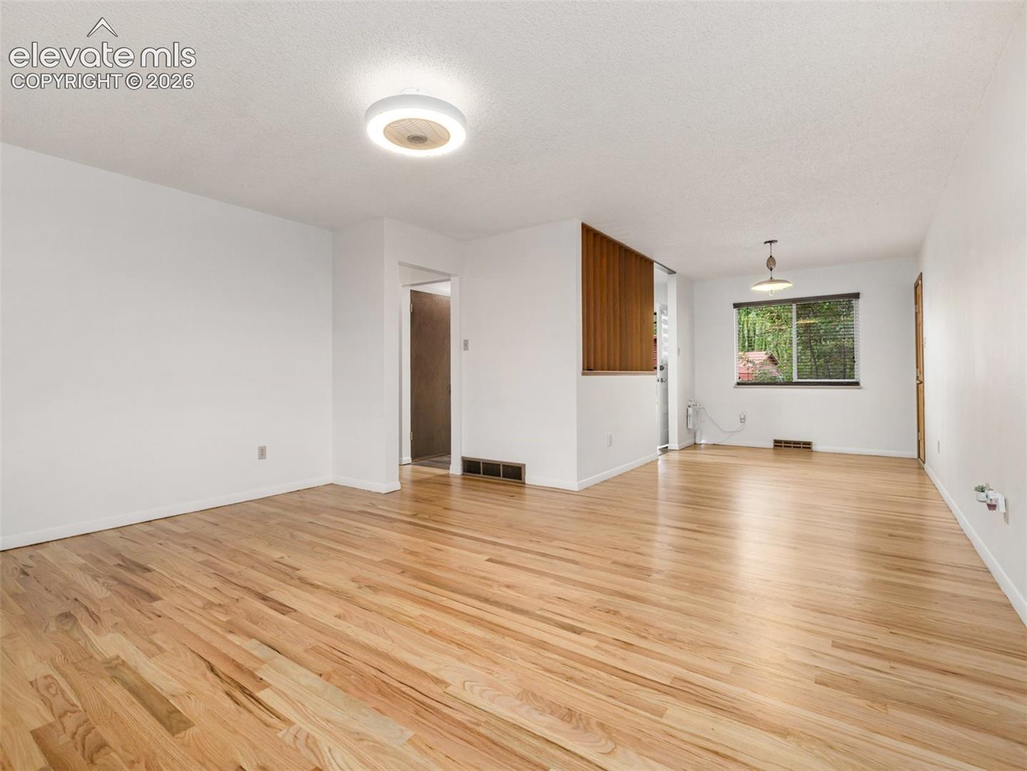 Wood-finish flooring, white walls, and a wood-slat partition