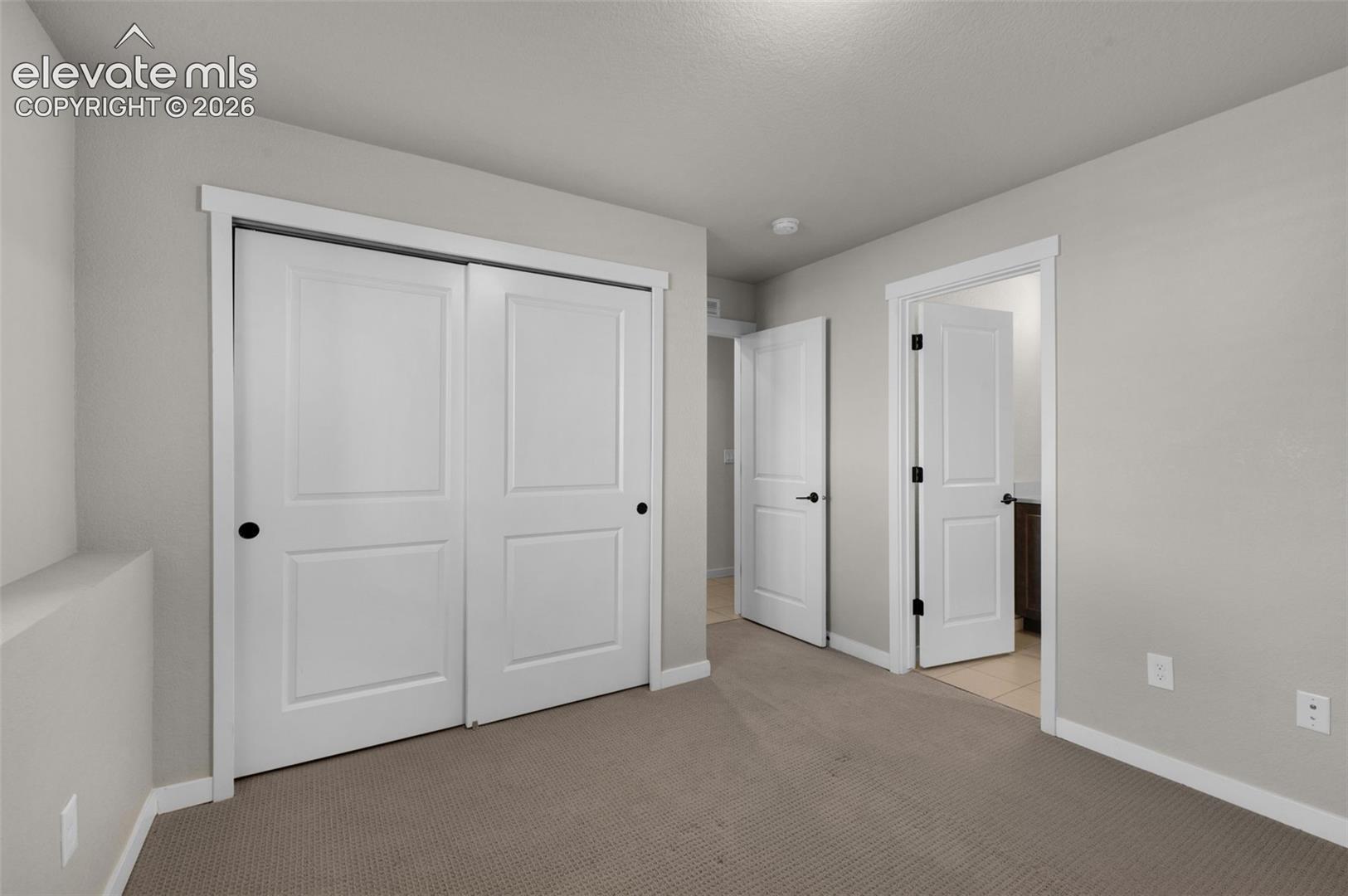 Wall-to-wall carpeting, white interior doors, and neutral wall paint