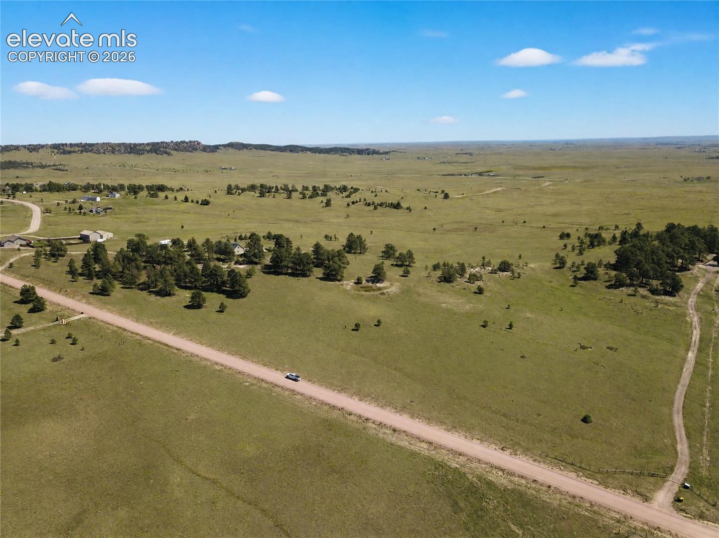 Expansive open terrain featuring natural grassland and scattered trees
