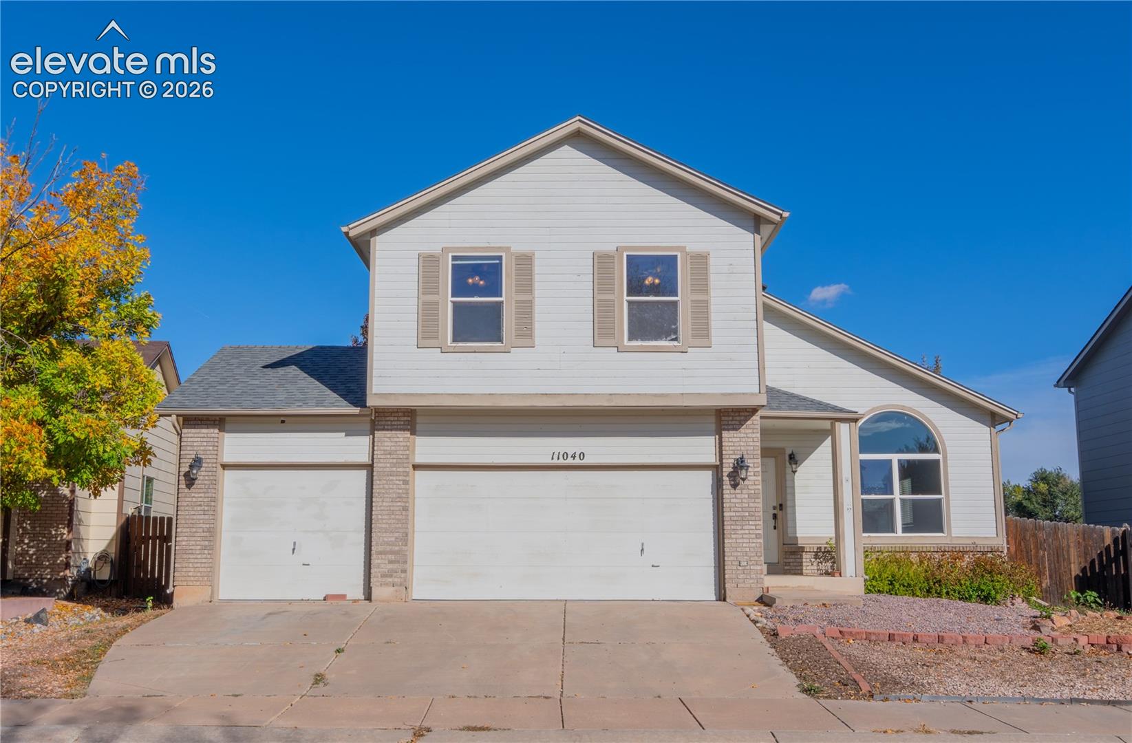 Welcoming two-story home with brick accents, mature trees, and an attached 3-car garage!