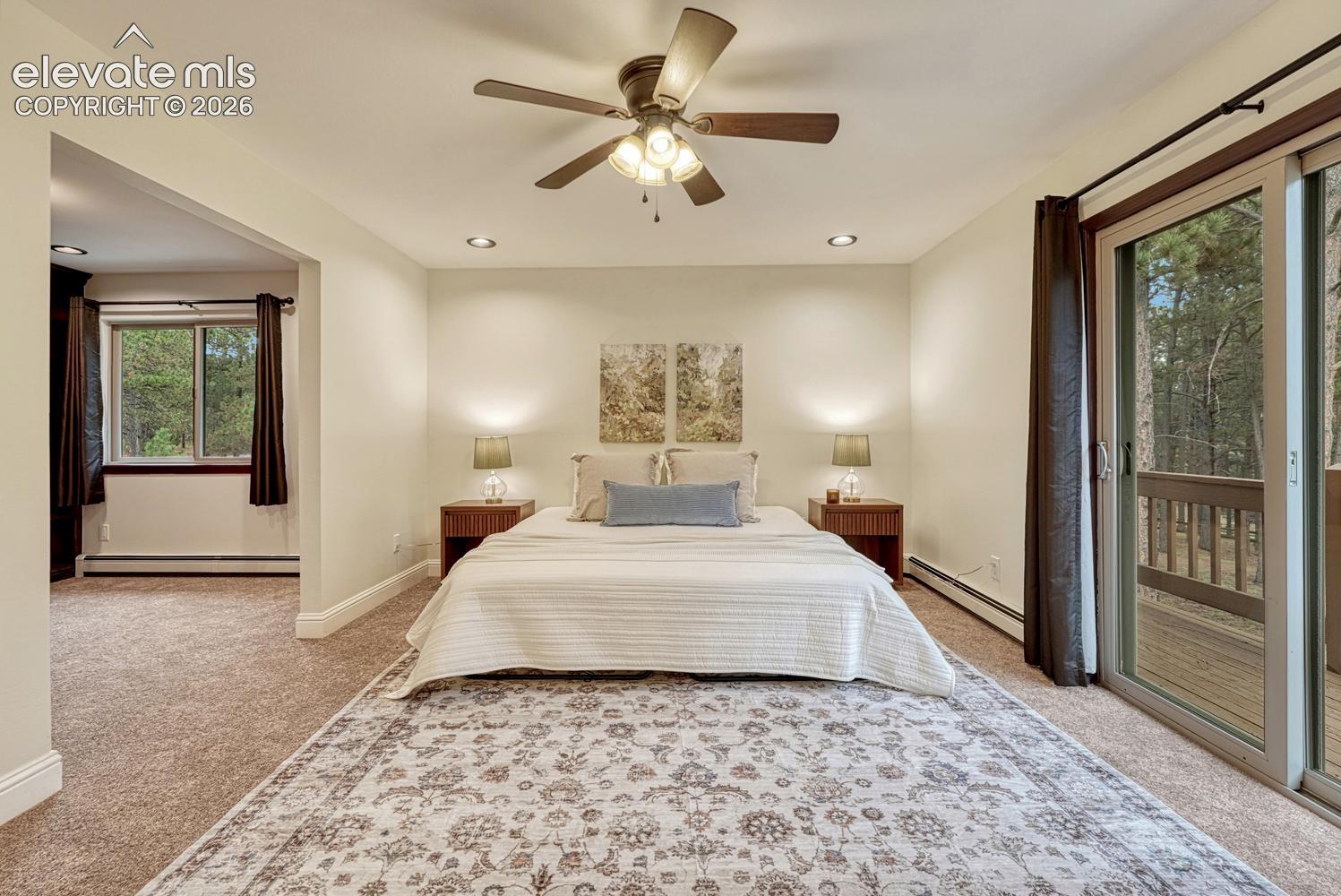 Room featuring recessed lighting, a multi-blade ceiling fan with integrated light fixture, neutral wall finishes, carpeted flooring, and a sliding glass door providing access to an exterior deck