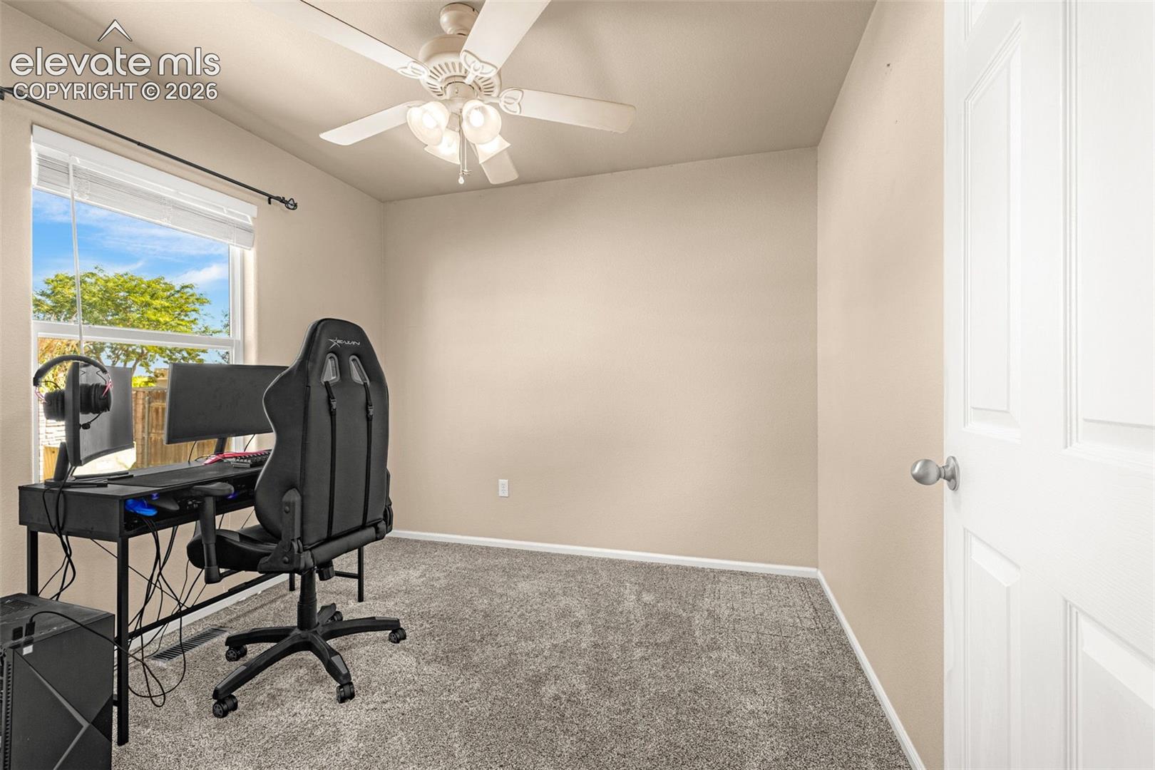 Recessed window with white blinds, neutral wall paint, ceiling fan with integrated lighting, and gray carpet