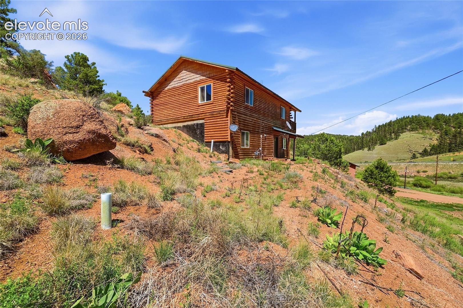 Log-style siding exterior with a covered porch and upper-level balcony