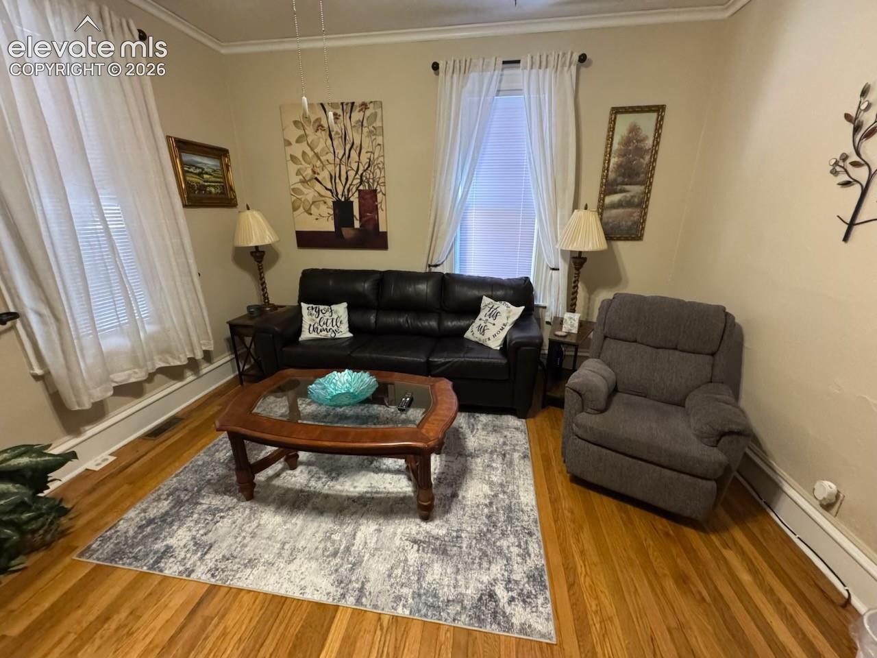 Hardwood flooring, crown molding, and substantial window trim