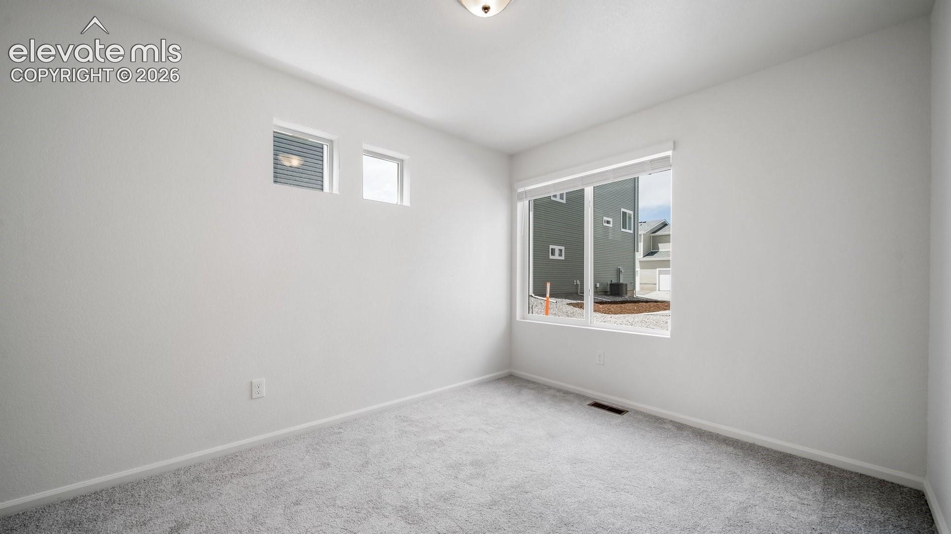 Neutral wall color with carpeted flooring, complemented by a large window and two transom windows
*photos of a model home*