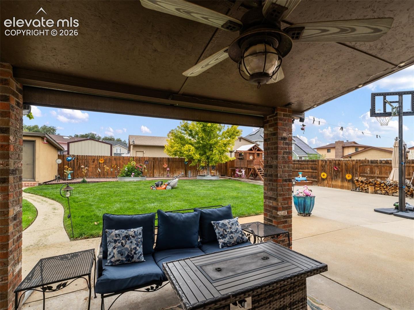 Covered patio with brick columns, ceiling fan, and recessed lighting