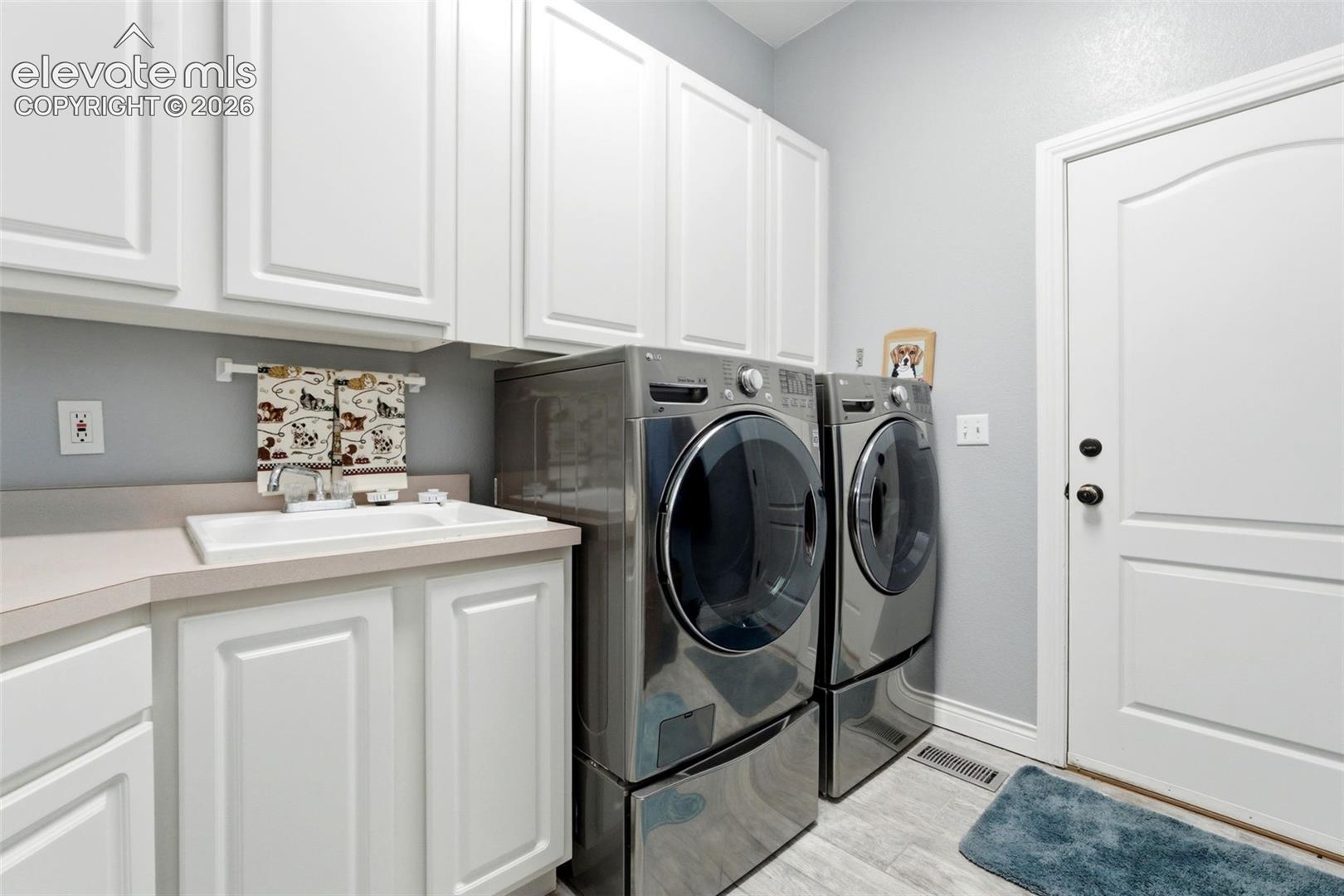 White shaker-style cabinetry, a built-in sink with a countertop, and light-toned flooring