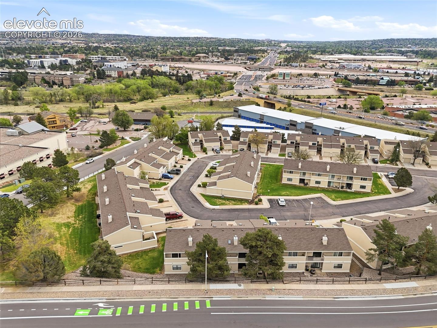 Aerial perspective showcasing a collection of multi-unit buildings with neutral-toned exteriors and brown shingle roofs