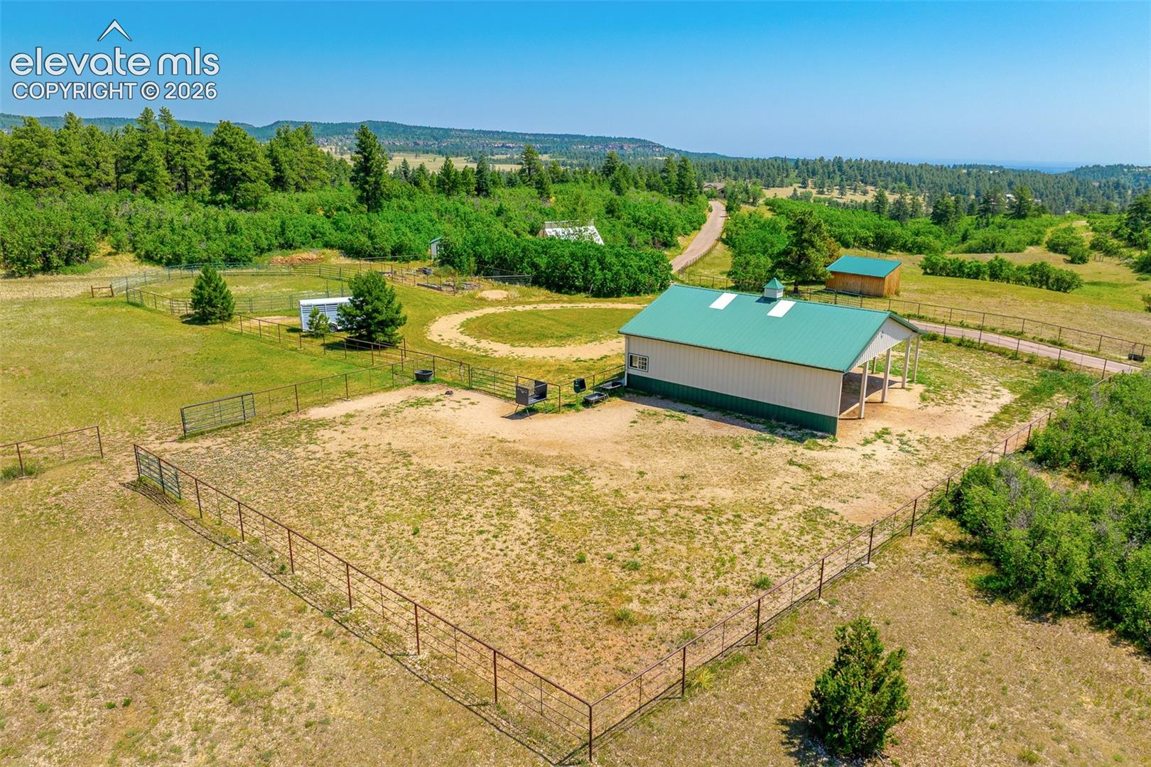 View of stable and pasture photographed June 2026